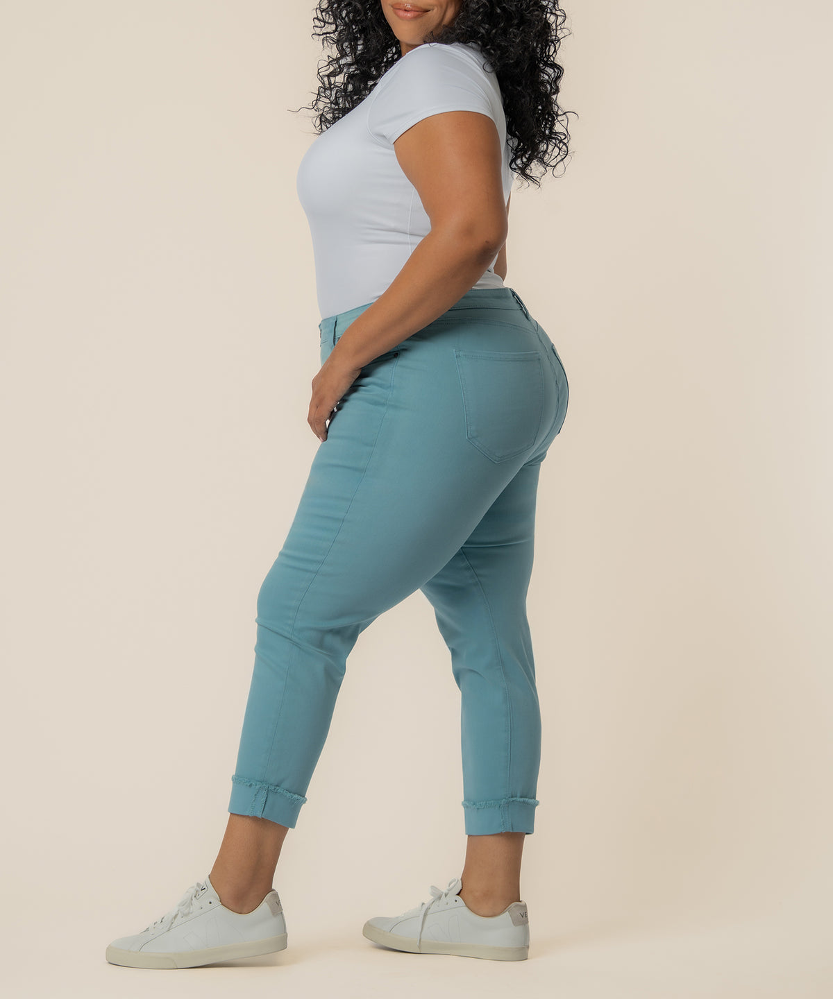 Cyan mid-rise crop straight leg pants with cuffed ankles and side pockets, worn with white sneakers.