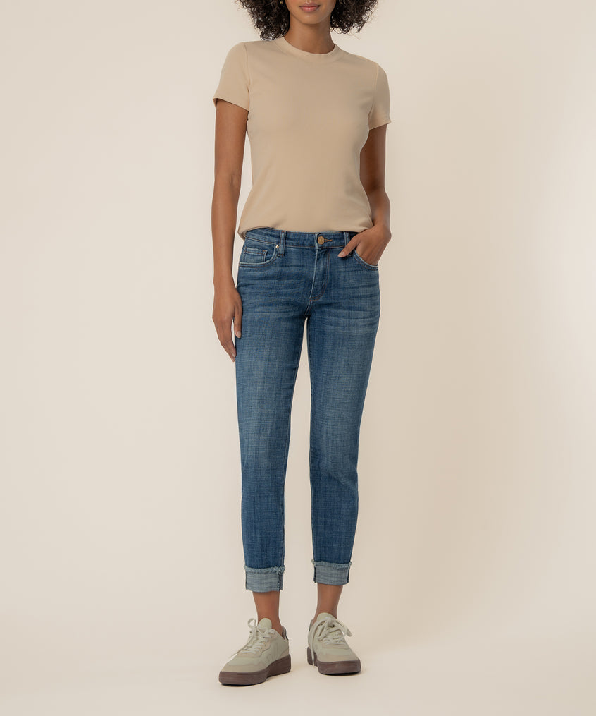 Woman wearing beige t-shirt and blue straight-leg crop jeans with cuffed ankles and cream platform shoes.