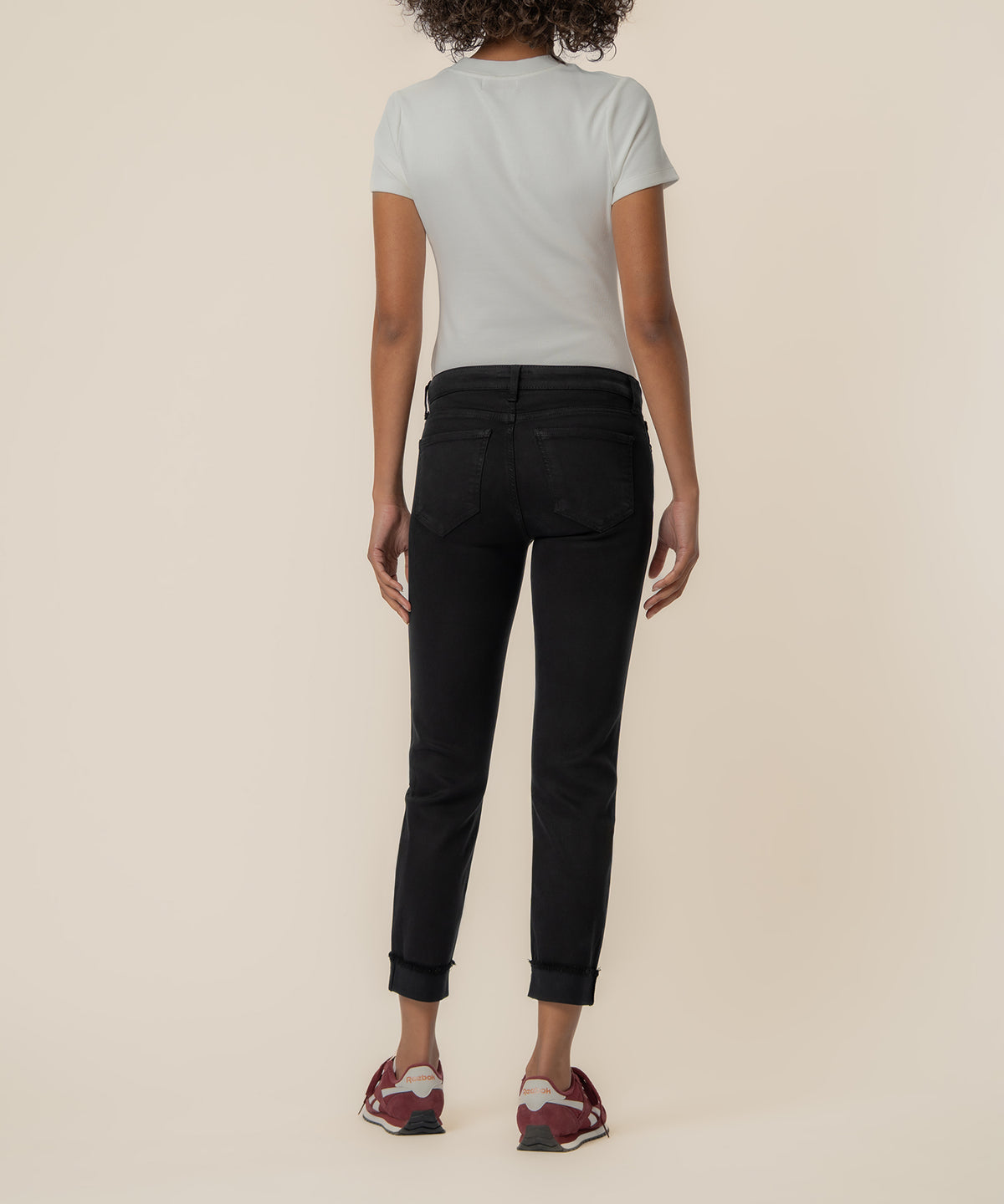 Black straight leg crop jeans with rolled cuffs, shown from back on model wearing white t-shirt.