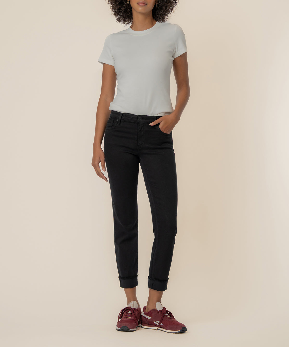 Woman wearing white short-sleeve t-shirt and black cropped straight-leg jeans with cuffed ankles.