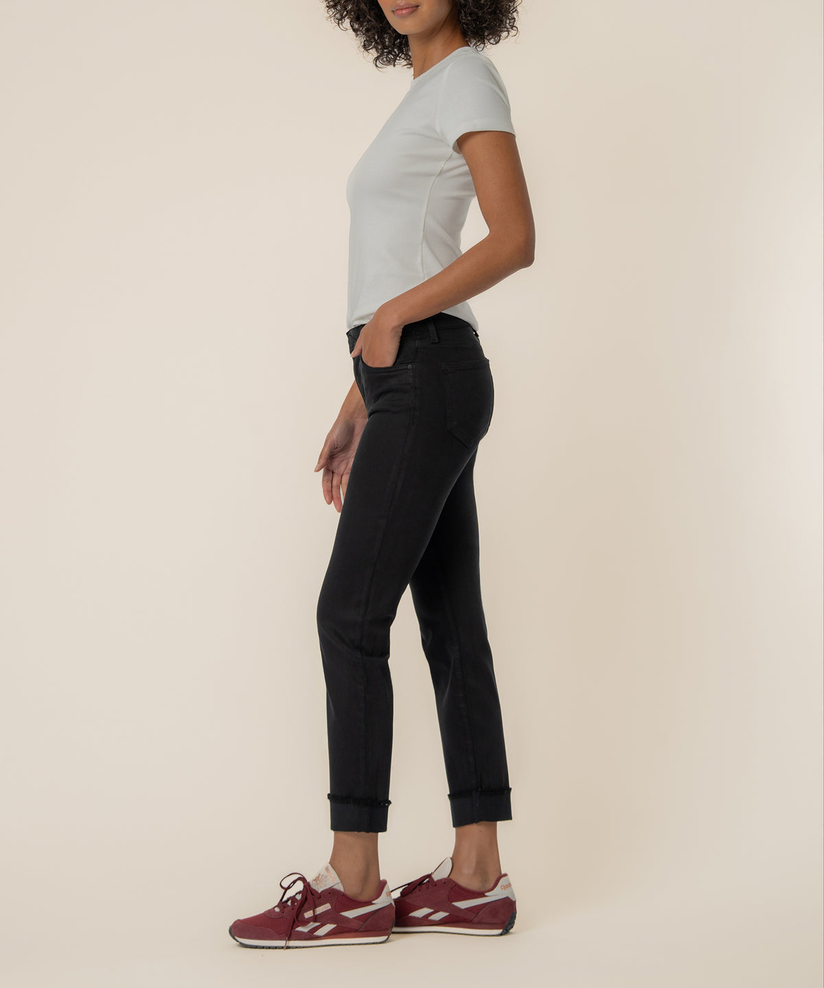 Woman wearing light gray t-shirt and black cropped straight-leg jeans with rolled hem.