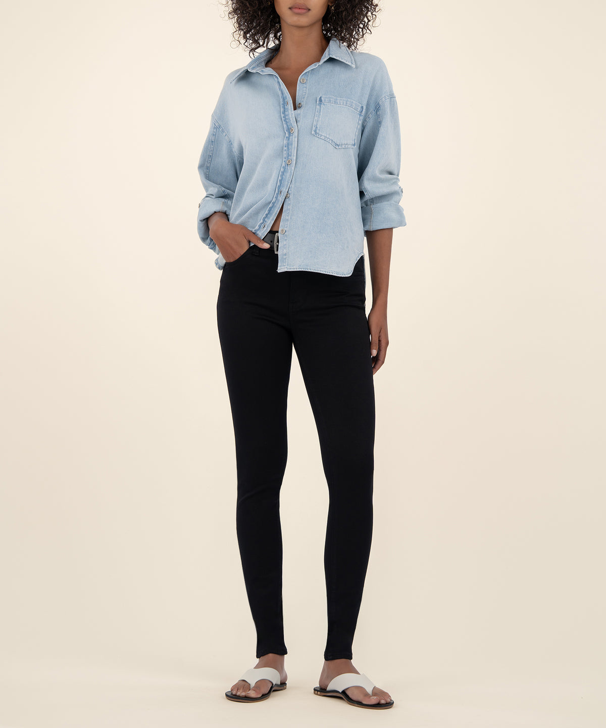 Black high-rise slim fit skinny jeans paired with light blue button-up denim shirt.