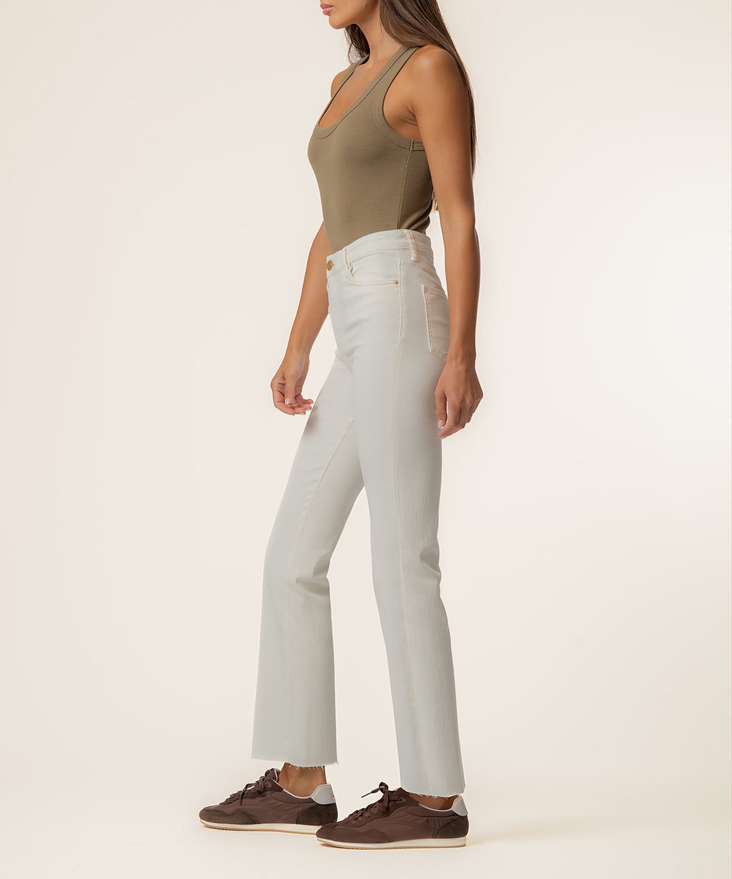 Ecru high-rise ankle flare jeans with a fitted waistband and subtle flare at the hem, shown on a model with a brown tank top.