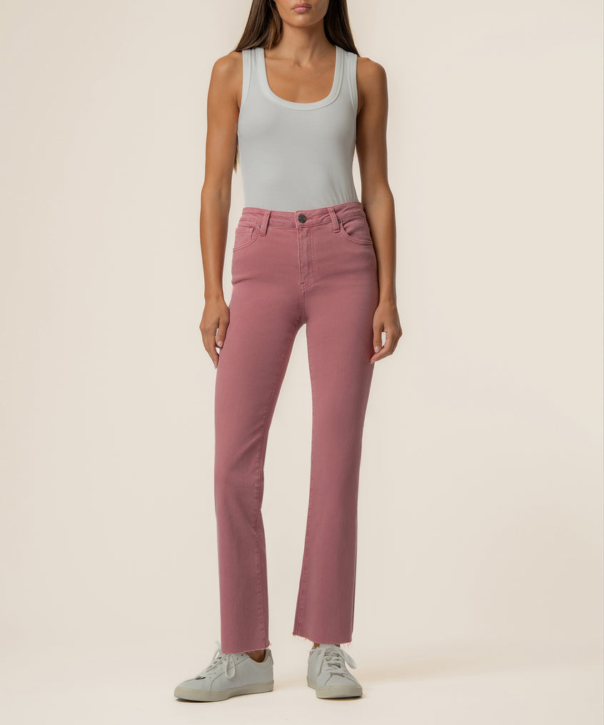 Woman wearing rose pink high-rise ankle flare jeans with a gray sleeveless tank top.