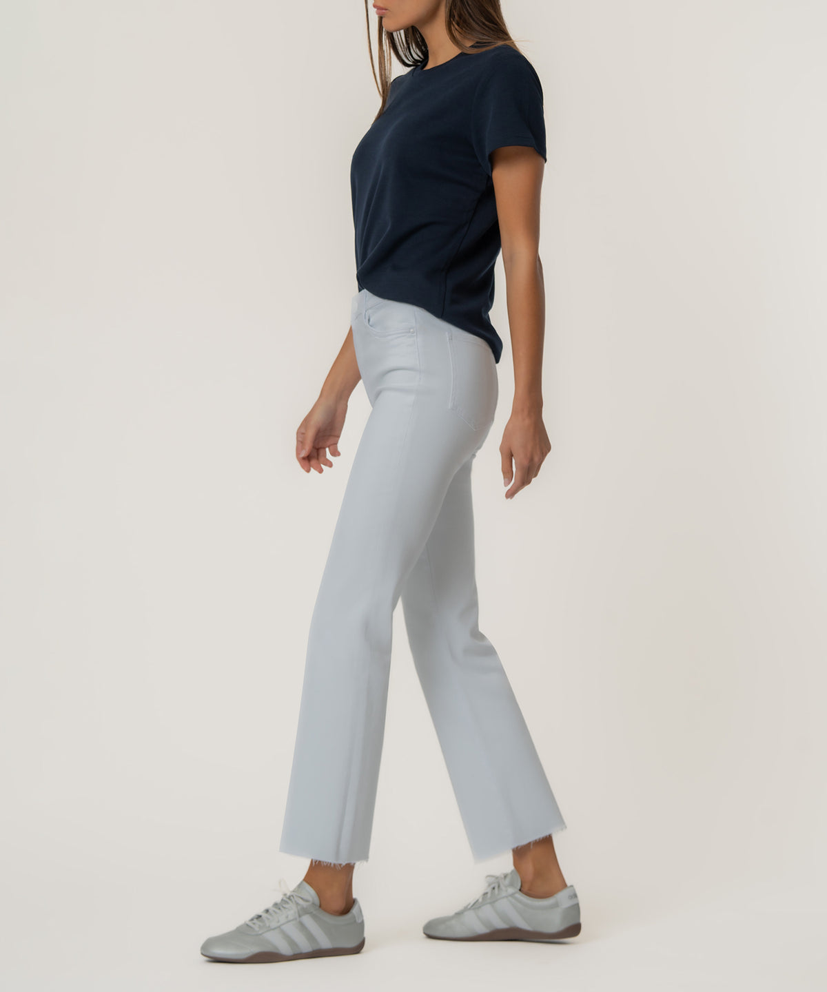 White high-rise ankle flare jeans with a frayed hem, shown styled with a navy t-shirt.