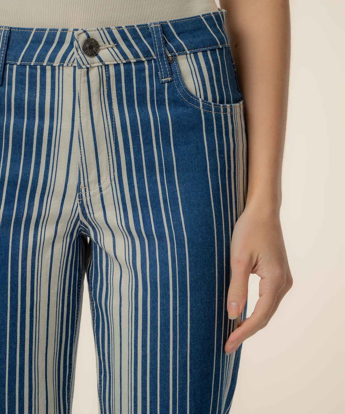 Navy and ivory striped twill pants with high rise waistband and ankle flare silhouette.