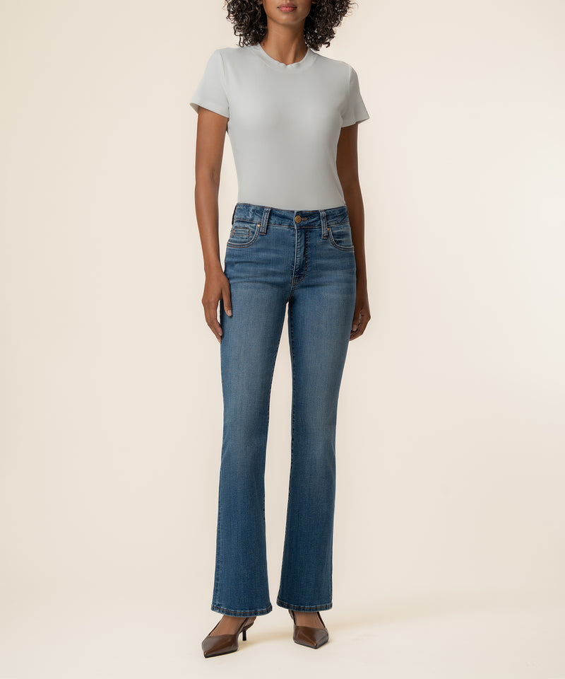 Woman wearing light gray t-shirt and blue bootcut jeans with high rise waistband.
