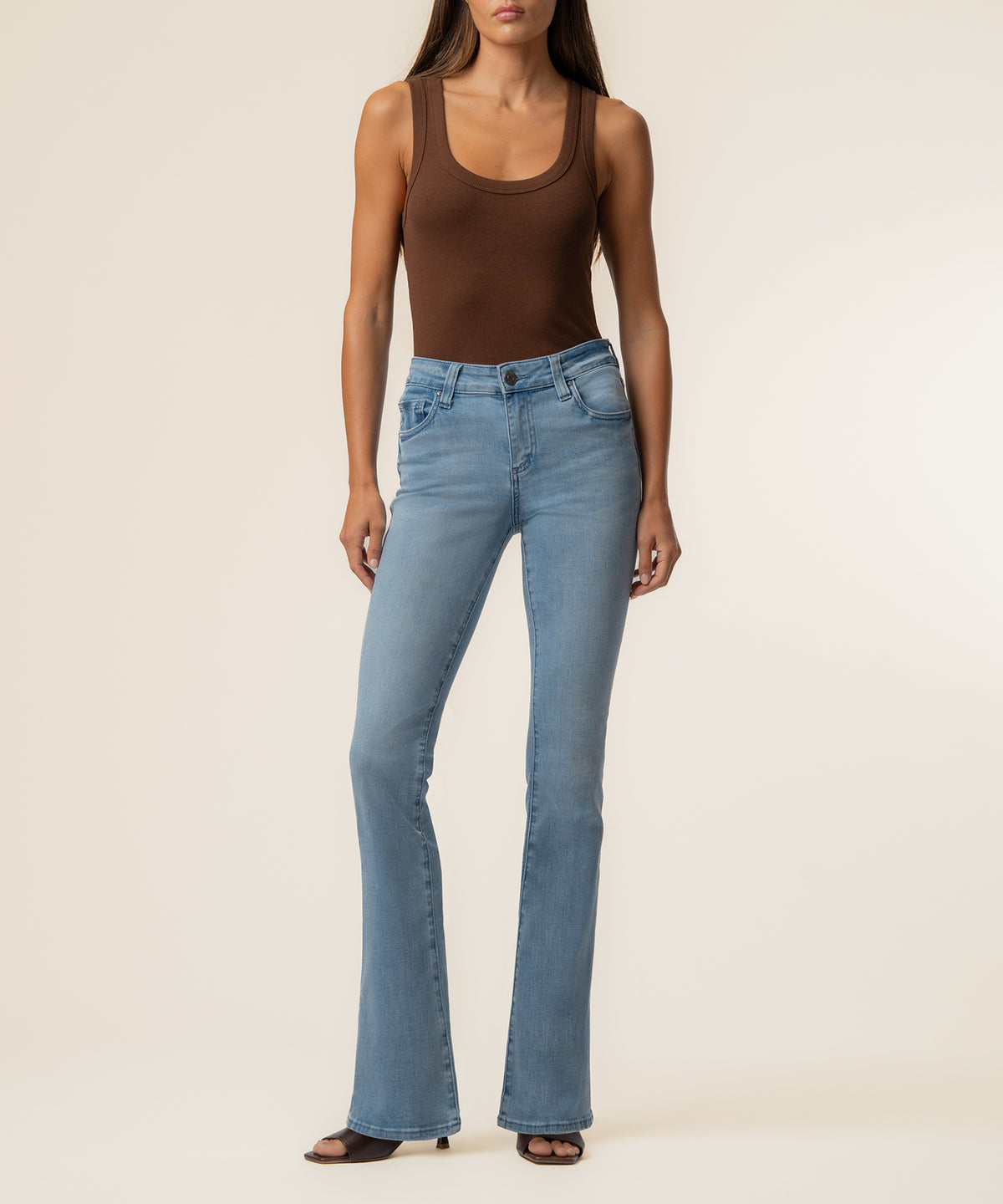 Light blue flare jeans with mid-rise waistband styled with brown sleeveless tank top.