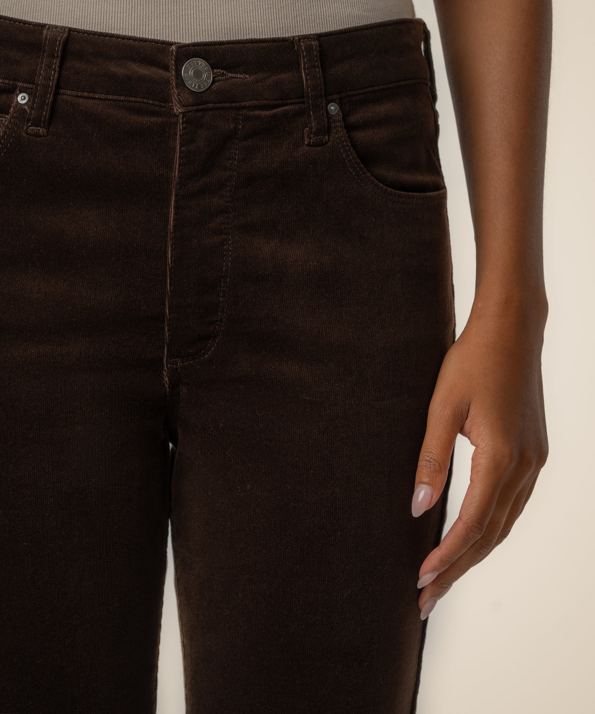 Brown corduroy high-rise flare pants with button closure and front pockets.