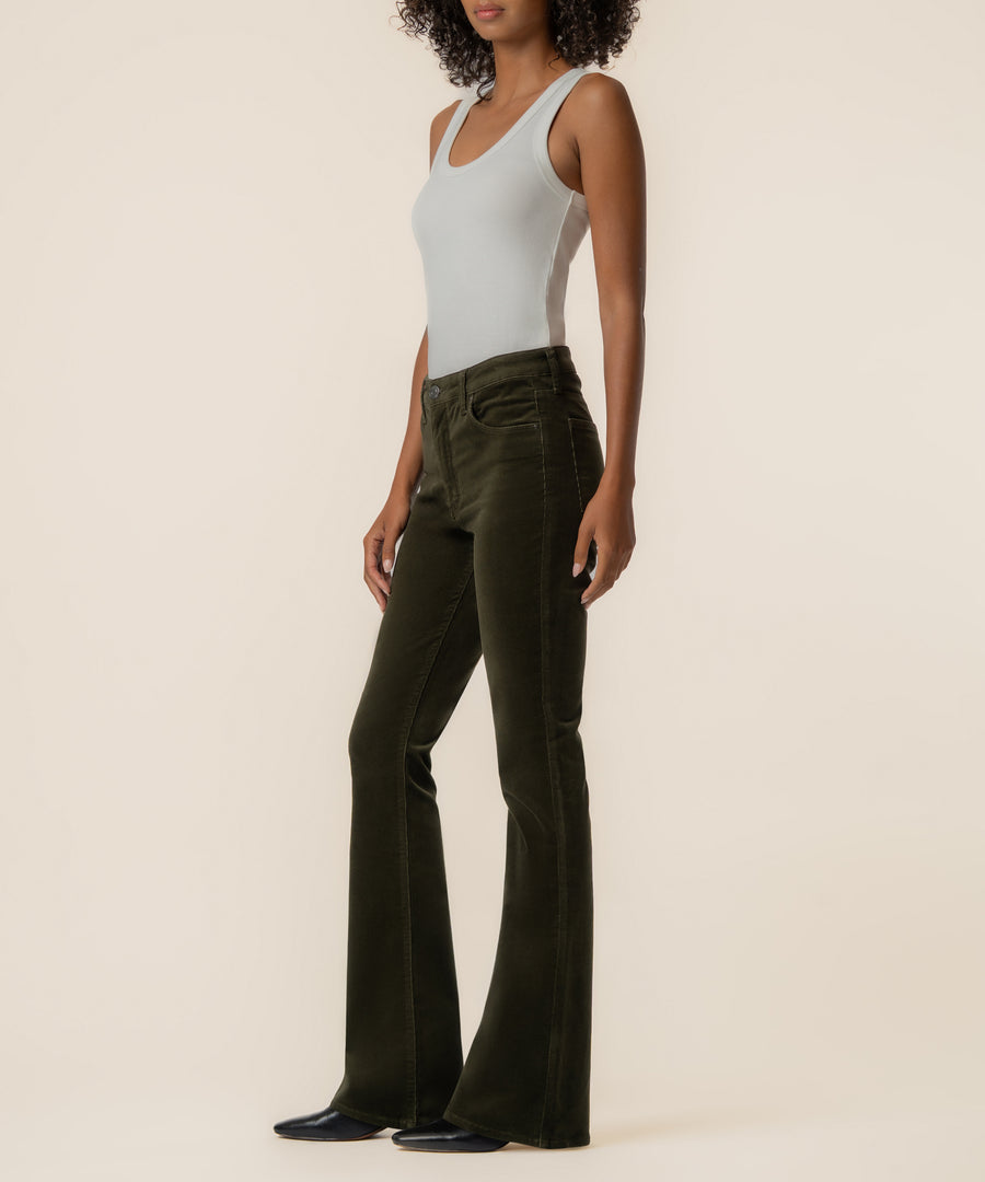 Olive corduroy high-rise flare pants with extended legs, styled with a white sleeveless tank top.