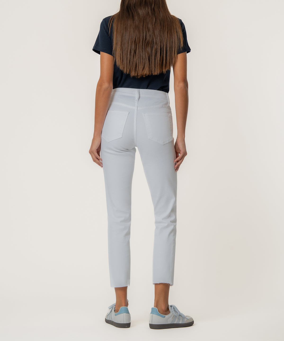White high-rise mom jeans with cropped ankle length and back pocket detail, shown from behind.