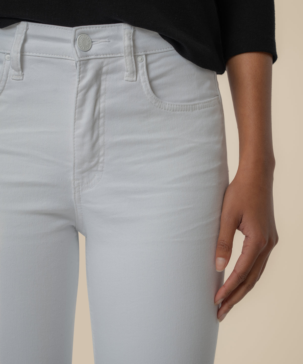 White high-rise mom jeans with button closure and five-pocket styling, paired with black top.