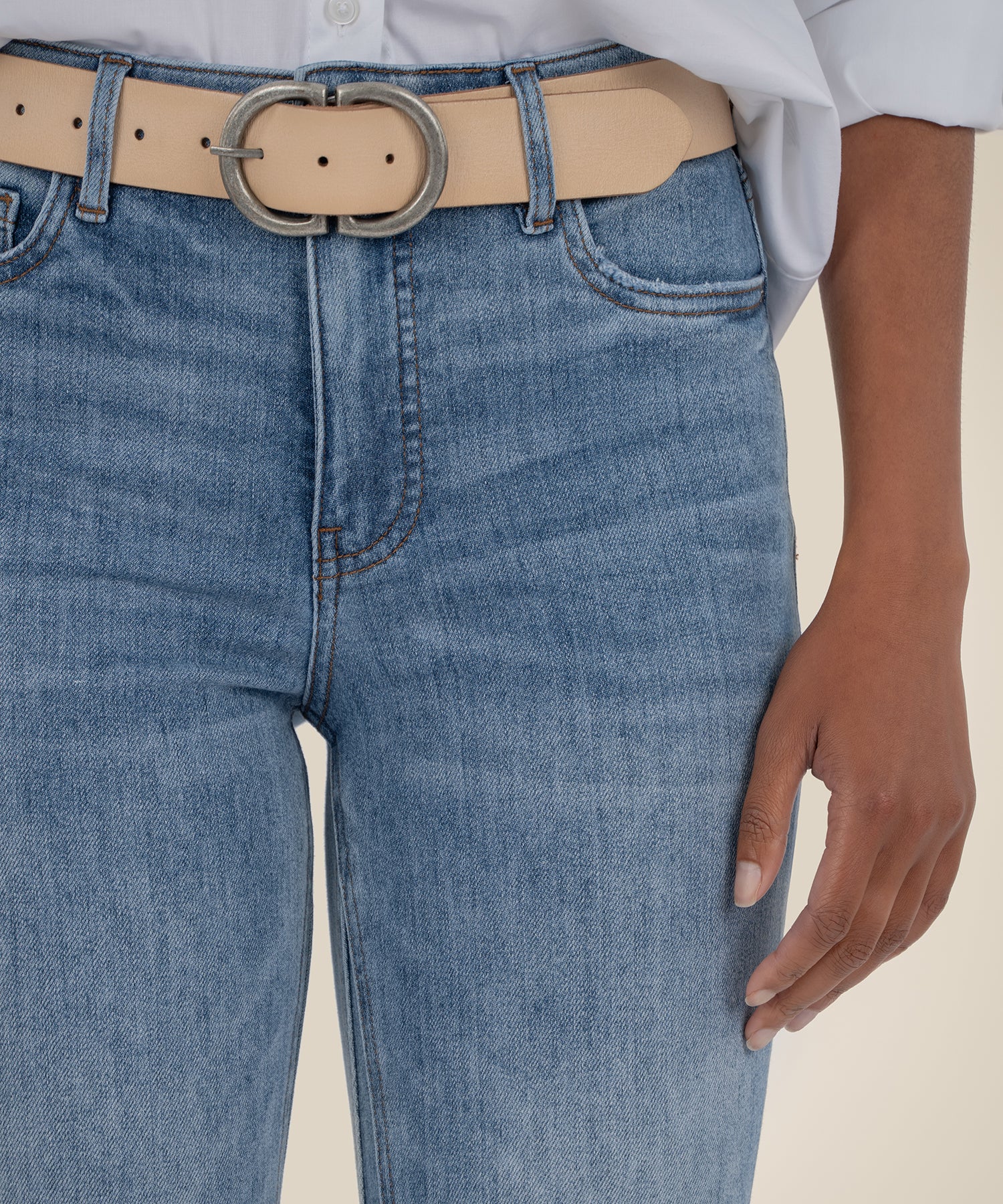 Light wash high-rise ankle flare jeans with tan belt featuring silver oval buckle.