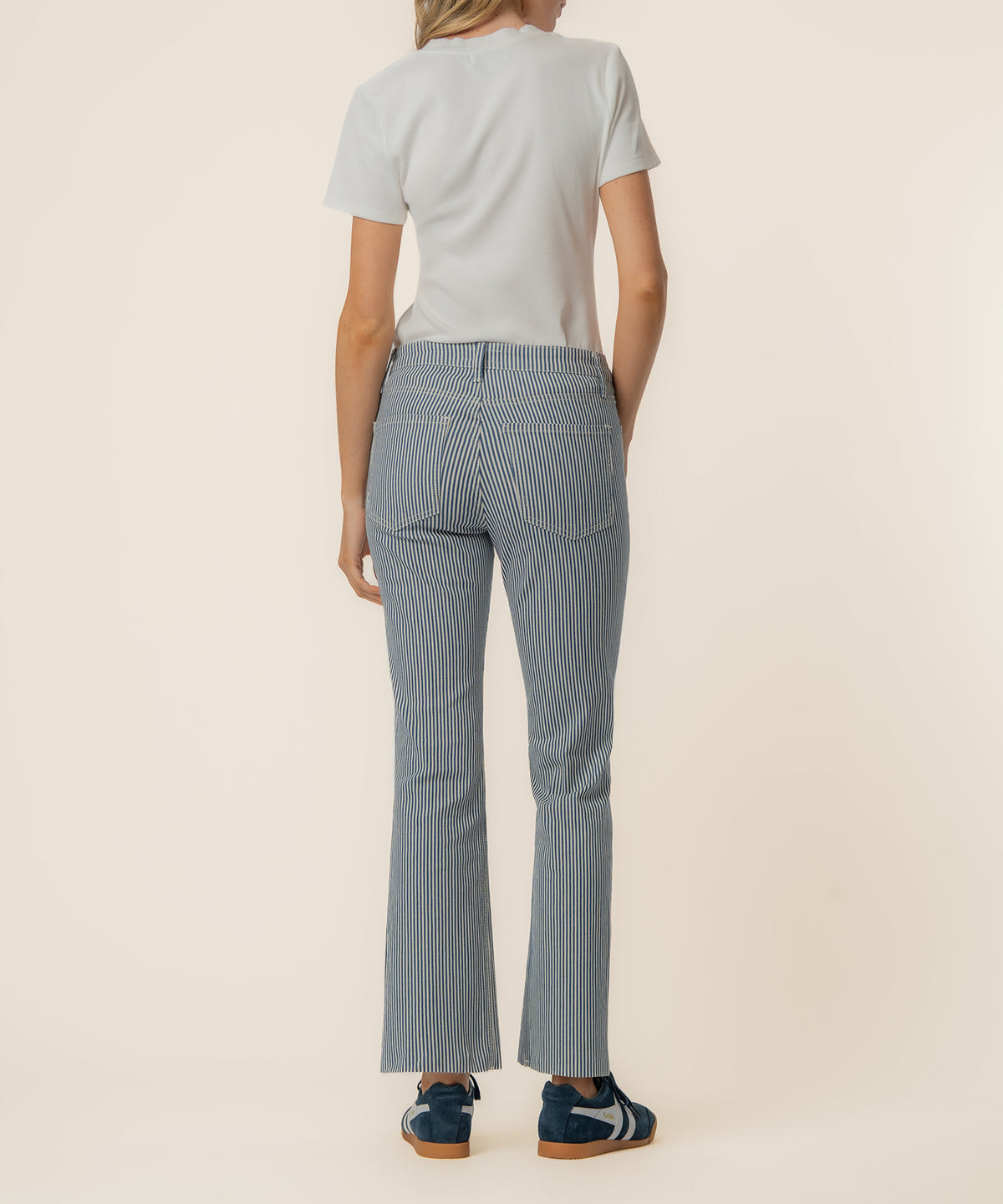 Navy and ivory vertical striped high-rise ankle flare pants worn with cream short-sleeve t-shirt, back view.