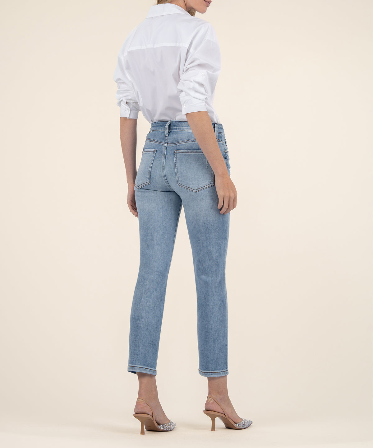 High-rise mom jeans in light blue wash with cropped straight leg and rolled hem, shown from back.