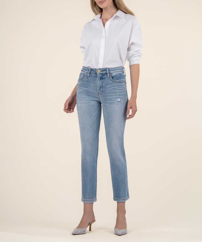 Woman wearing light blue high-rise mom jeans with a white button-up shirt and sparkly heels.