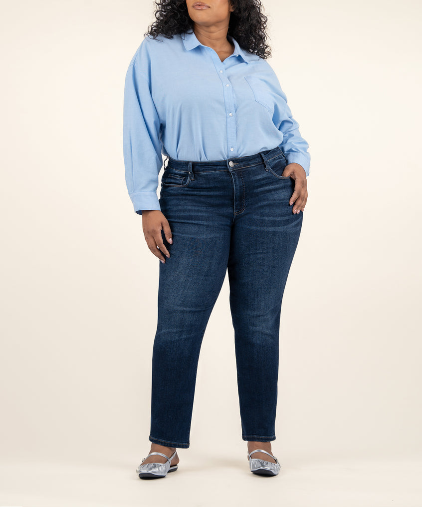 Woman wearing light blue button-up shirt and dark indigo straight-leg jeans with ankle length.
