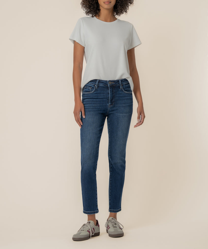 Woman wearing light gray t-shirt and medium-wash blue straight-leg ankle jeans with cuffed hem.