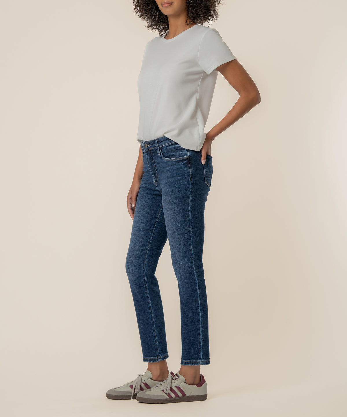 Dark blue high-rise ankle straight jeans with cropped hem on model wearing white t-shirt.