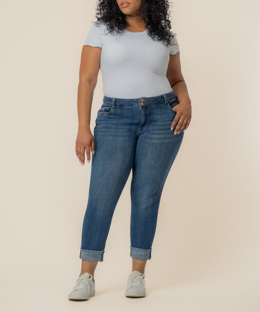 Woman wearing light blue t-shirt and mid-rise blue crop straight jeans with cuffed ankles and white sneakers.
