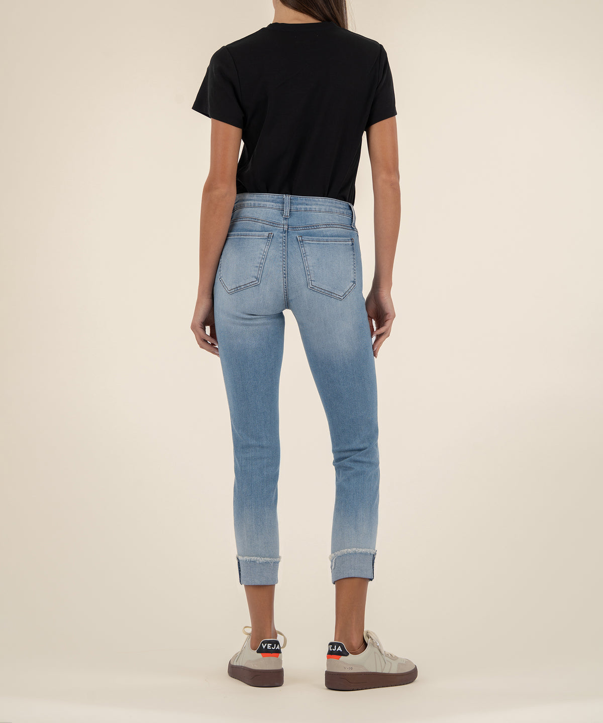 Light blue cropped straight-leg jeans with frayed cuffs, shown from back on model wearing black t-shirt.