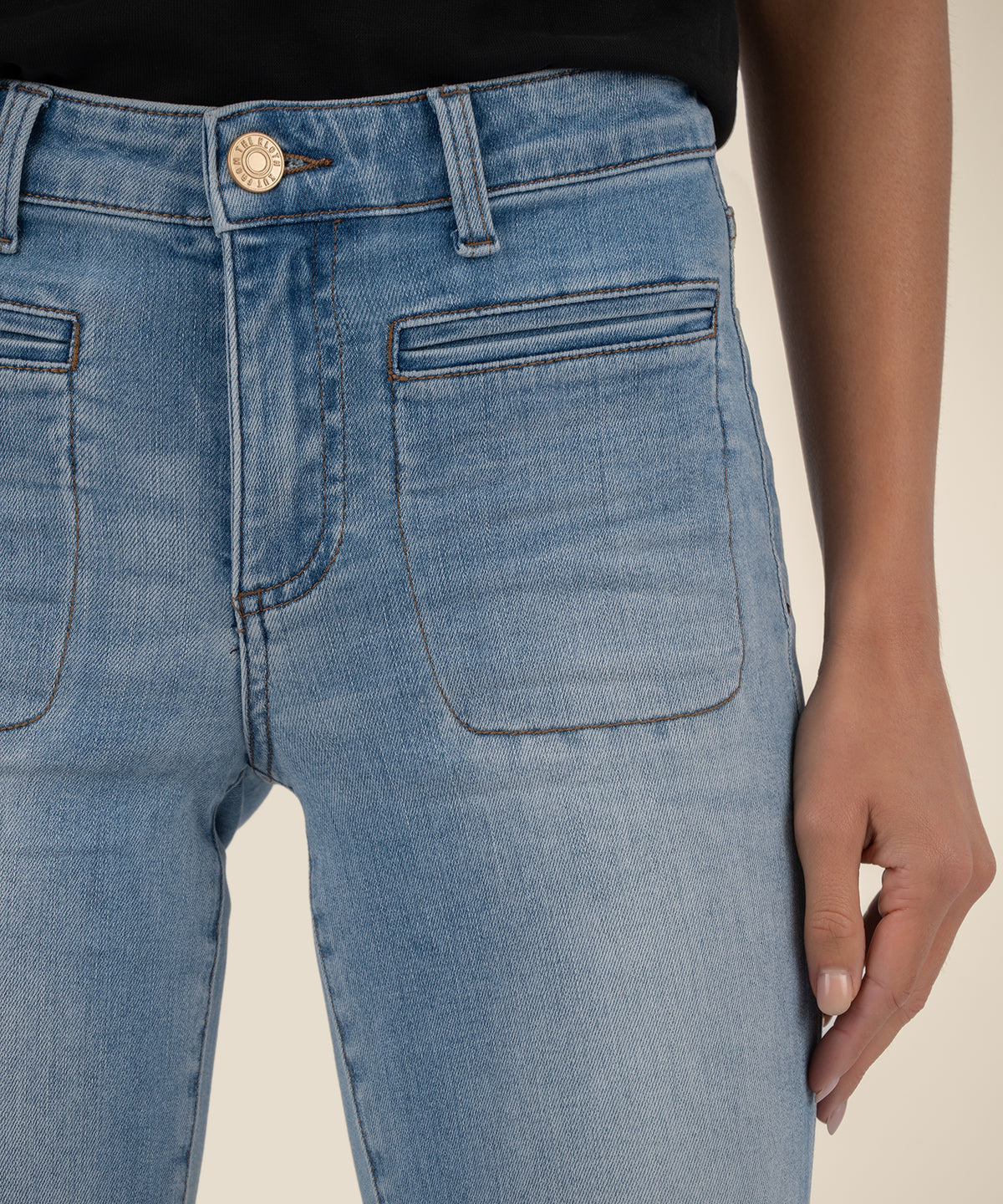 Light blue denim crop straight leg jeans with metal button, belt loops, and front pockets on model.