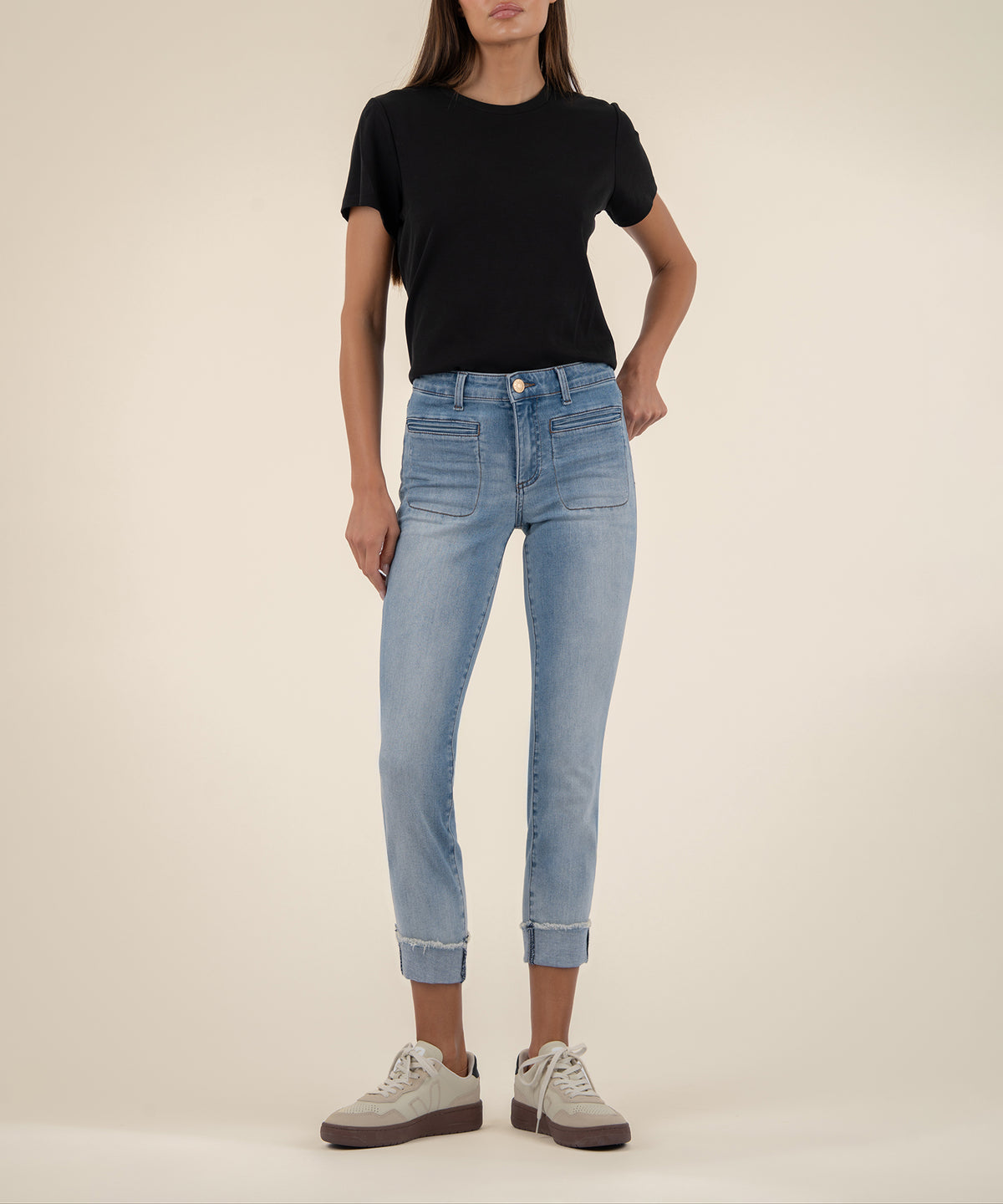 Woman wearing black short-sleeve t-shirt and light blue straight-leg crop jeans with cuffed ankles.