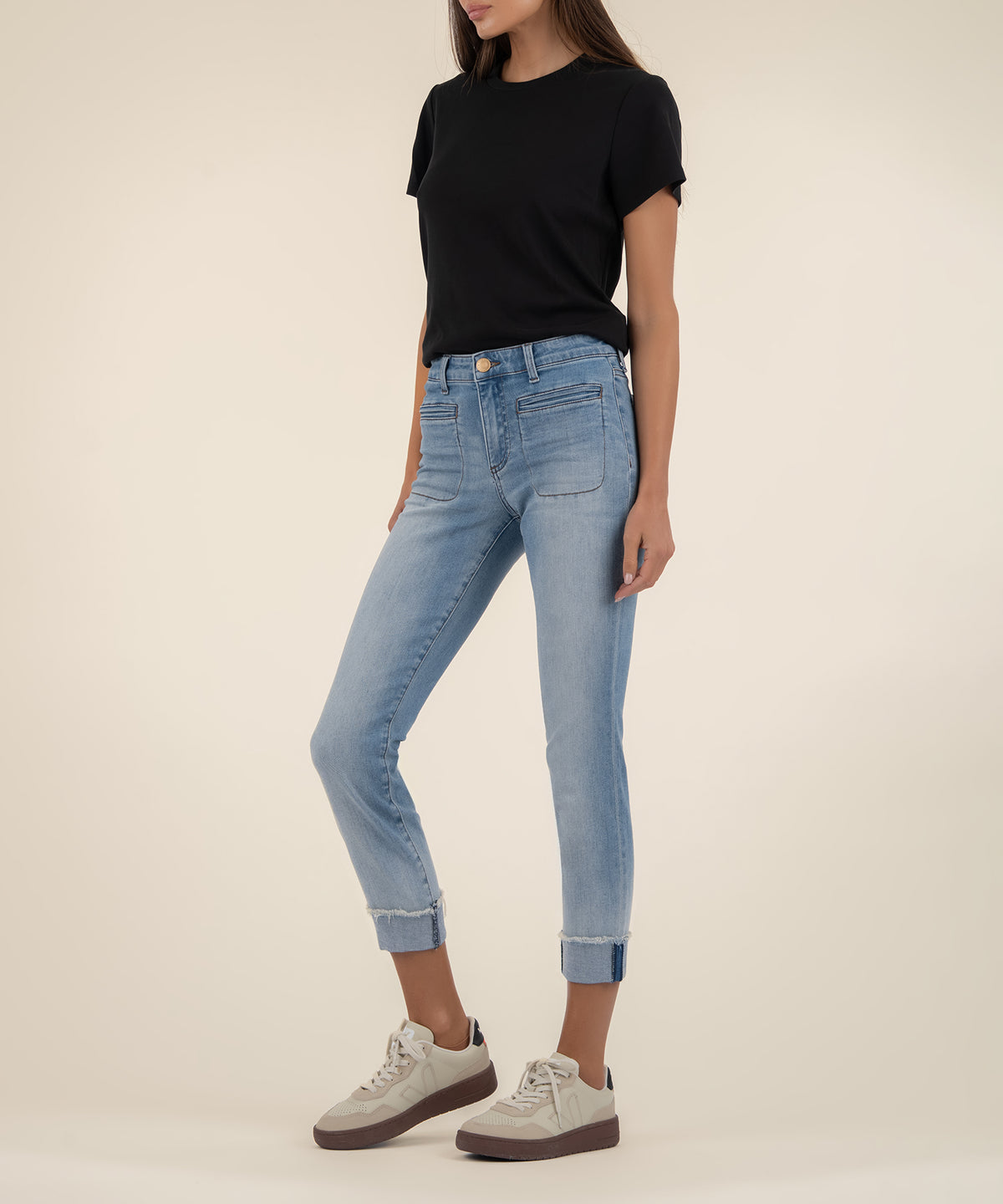 Woman wearing light blue cropped straight-leg jeans with rolled cuffs and a black short-sleeve shirt.