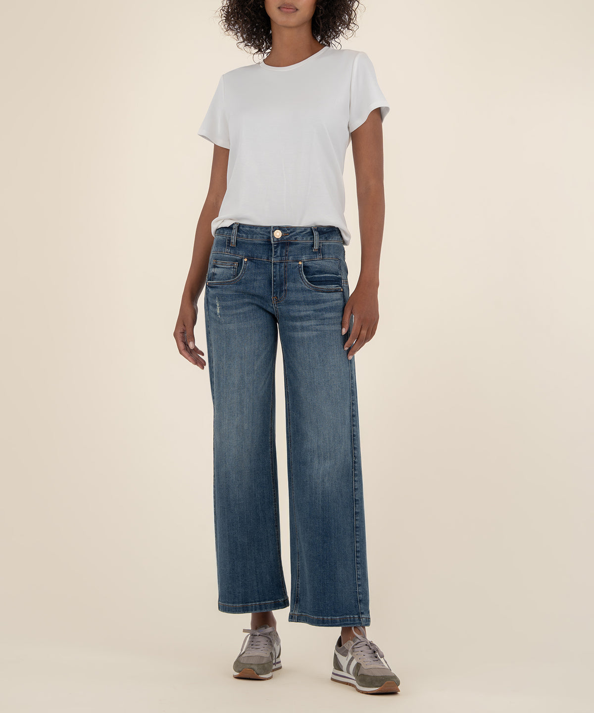 Woman wearing white short-sleeve t-shirt and high-rise wide-leg blue jeans in medium wash.