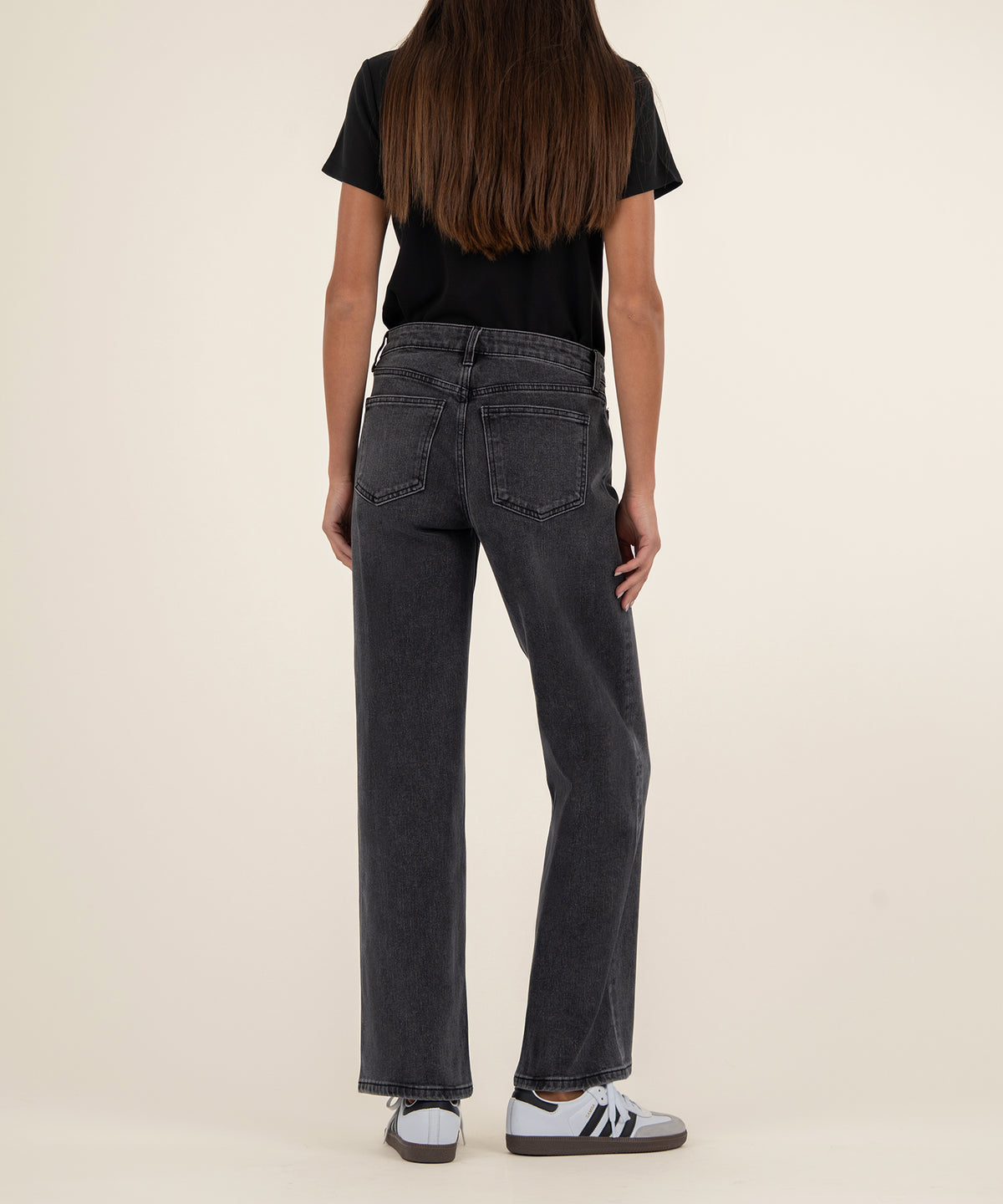 Dark gray baggy straight-leg jeans with low rise waistband, shown from back on model wearing black t-shirt.