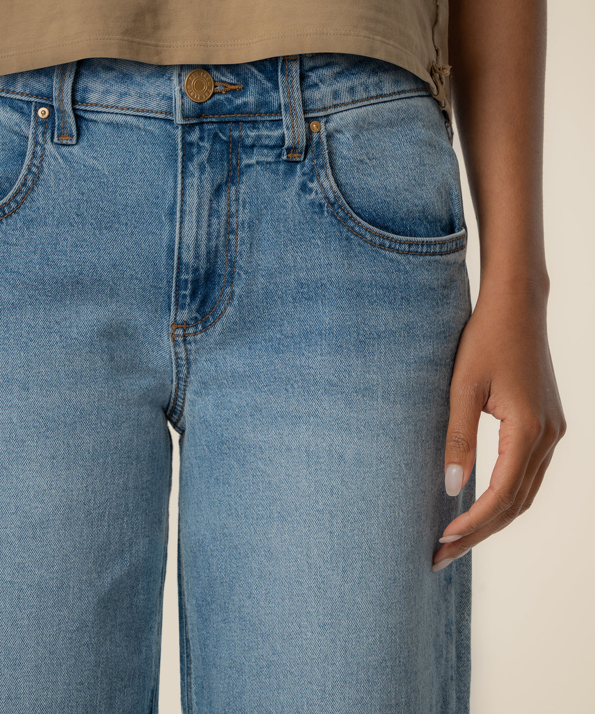 Light blue baggy low-rise straight leg jeans with gold button and visible stitching detail.