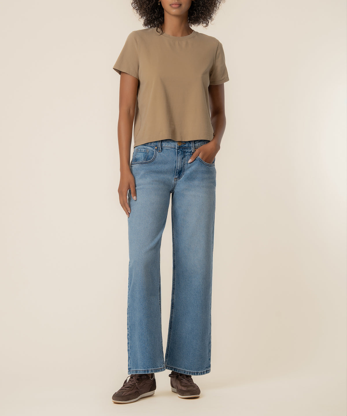 Light blue baggy straight leg jeans with low rise waistband, shown on model wearing tan t-shirt.