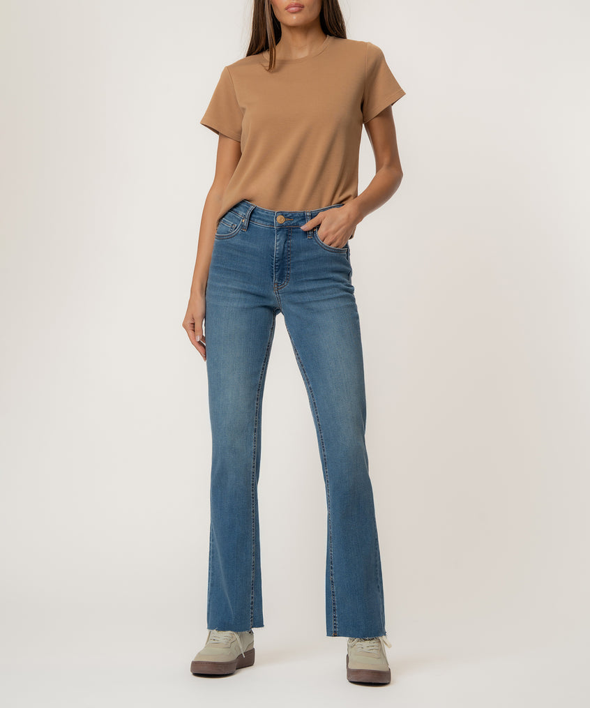 Woman wearing a tan t-shirt and blue high-rise flare jeans with a medium wash.