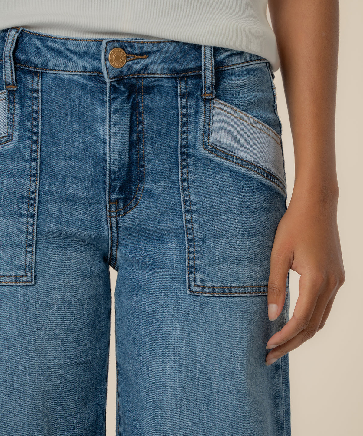 High-rise wide-leg jeans in medium blue wash with gold button and patch pockets.