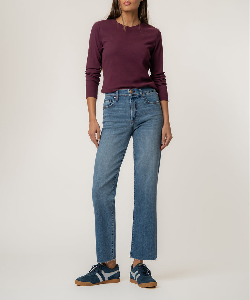 Light blue straight leg jeans with high rise waistband, shown with burgundy long-sleeve top and navy sneakers.