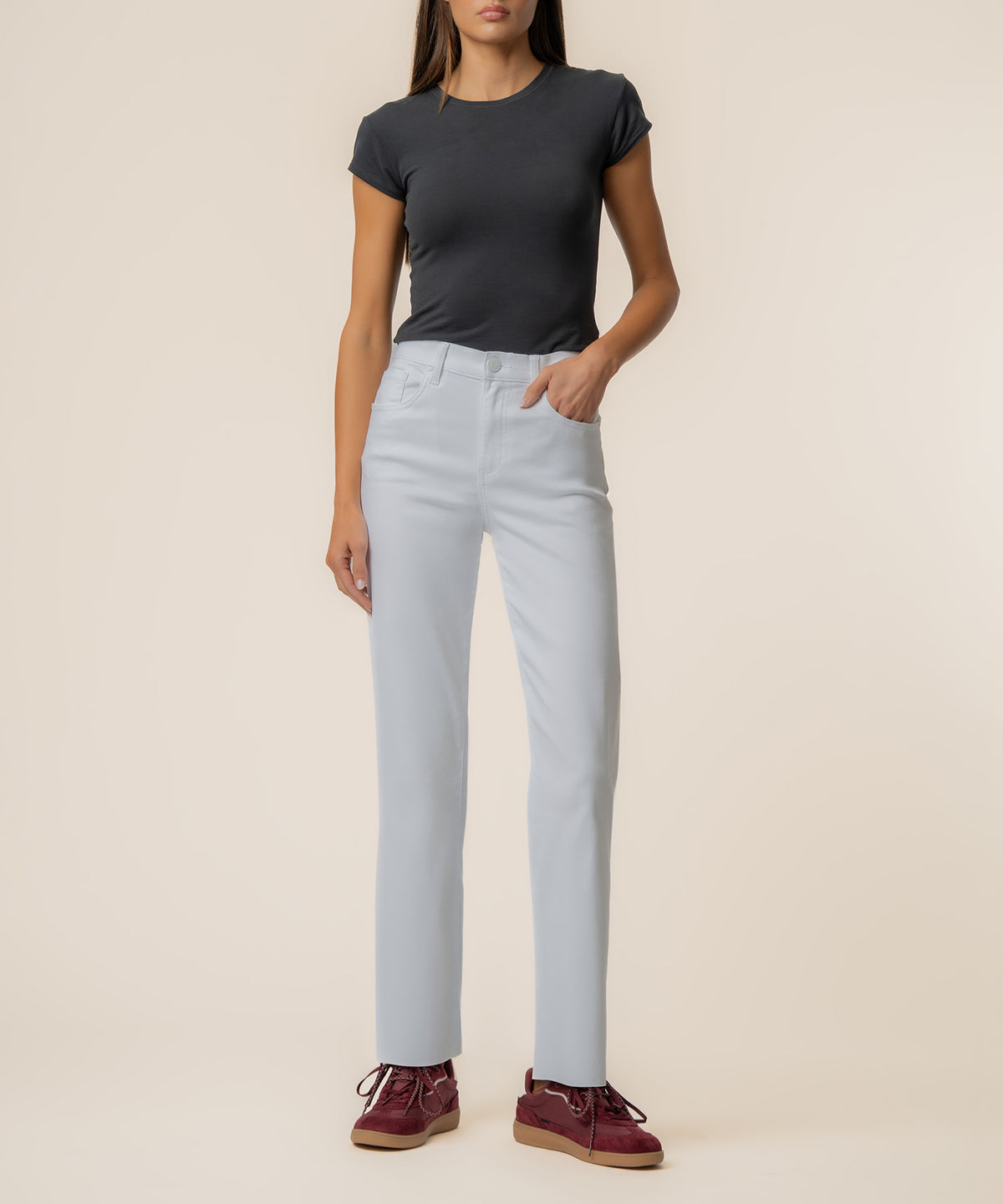 Woman wearing optic white high-rise straight-leg jeans with a black short-sleeve shirt and burgundy lace-up boots.