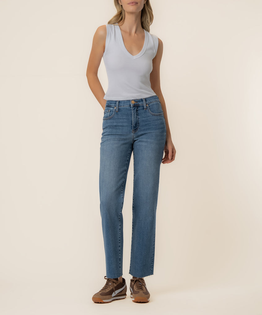 Woman wearing light blue sleeveless v-neck top and high-rise straight leg medium wash denim jeans.