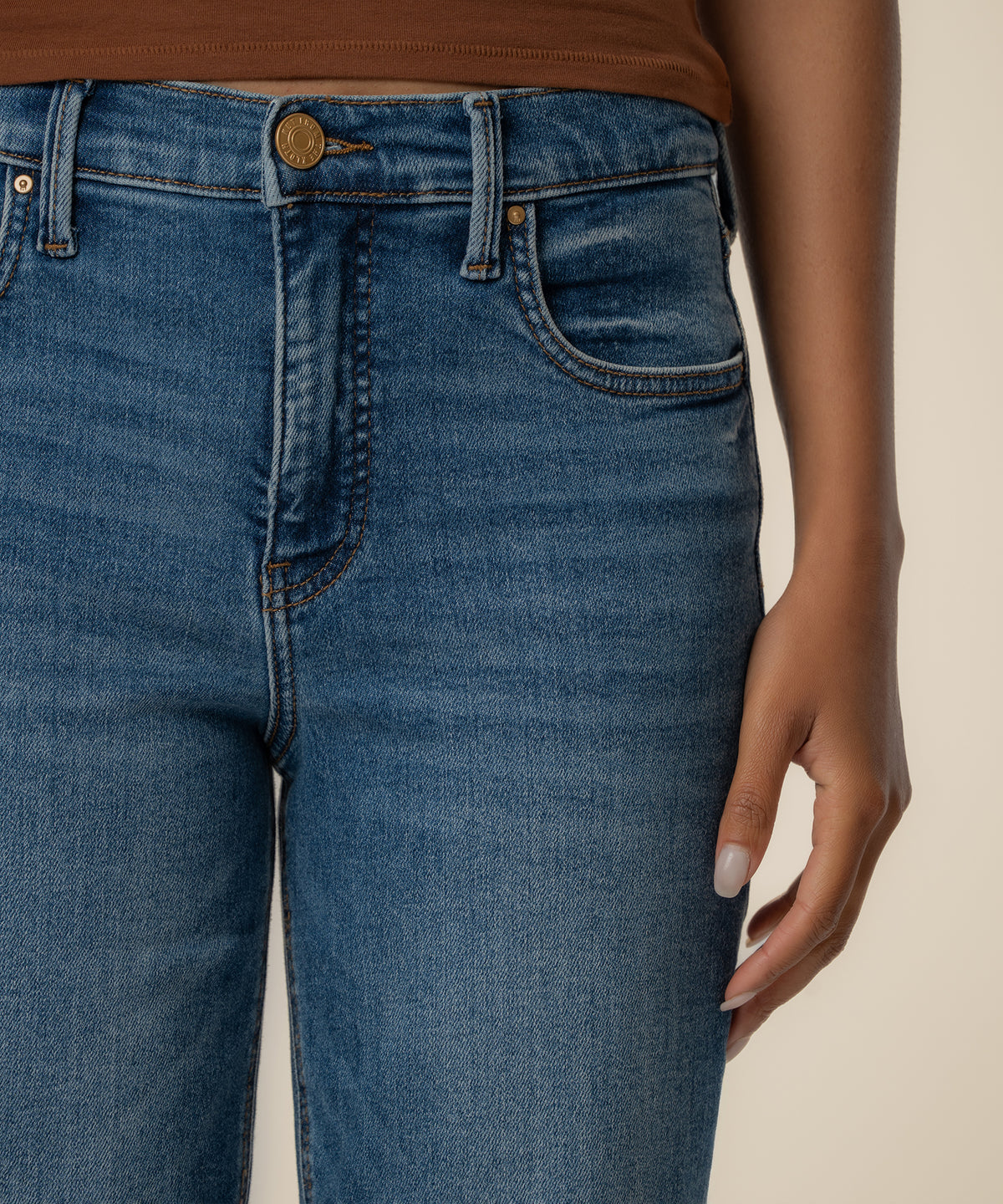 High-rise straight-leg jeans in medium blue wash with five-pocket styling and brass button closure.