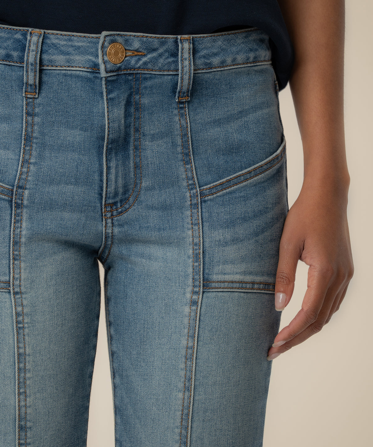 High rise ankle flare jeans in light blue articulated wash with contrast stitching and brass button.