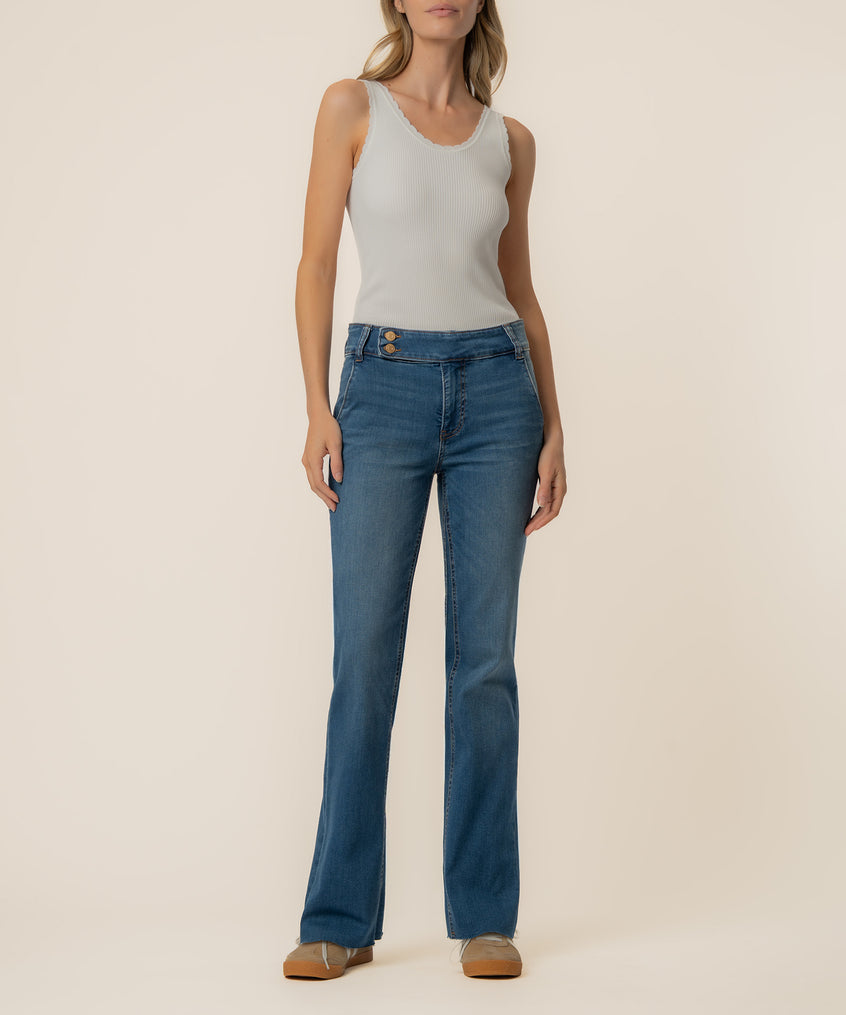 Woman wearing light gray ribbed tank top and medium-wash high-rise flare jeans with button waistband.