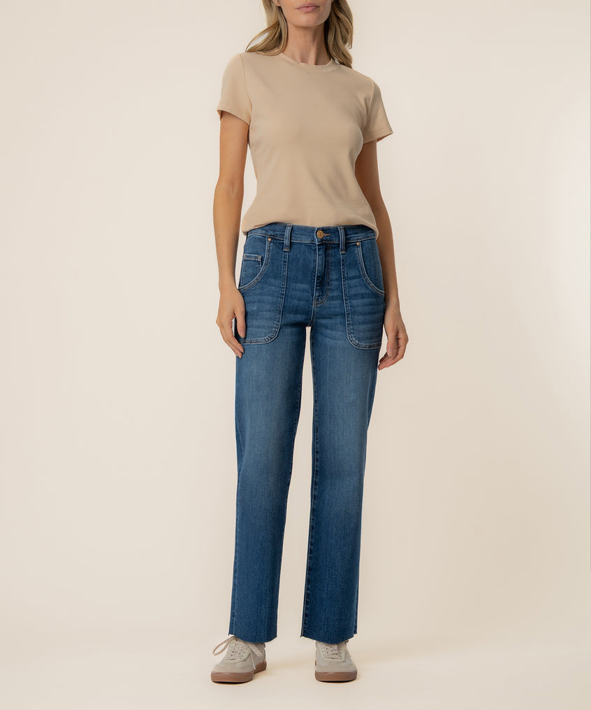 Woman wearing beige t-shirt and blue medium-wash high-rise straight-leg jeans with patch pockets.