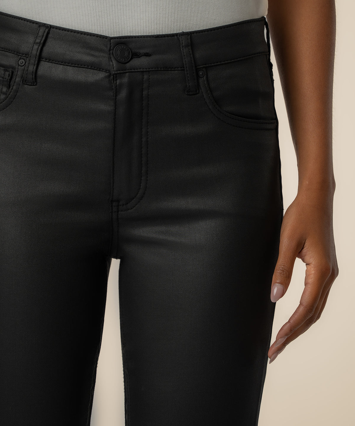Black coated high-rise flare jeans with button closure and front pockets, shown from waist to thigh.