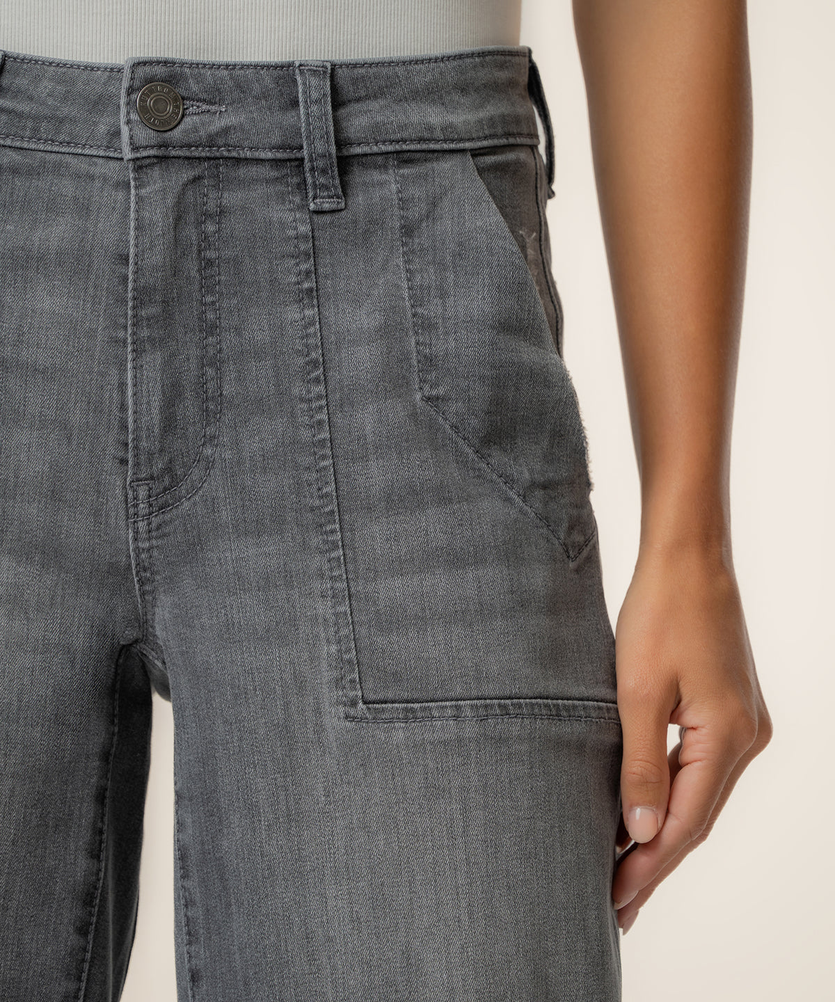 Gray high-rise relaxed leg jeans with button closure and visible seaming detail on the thigh.