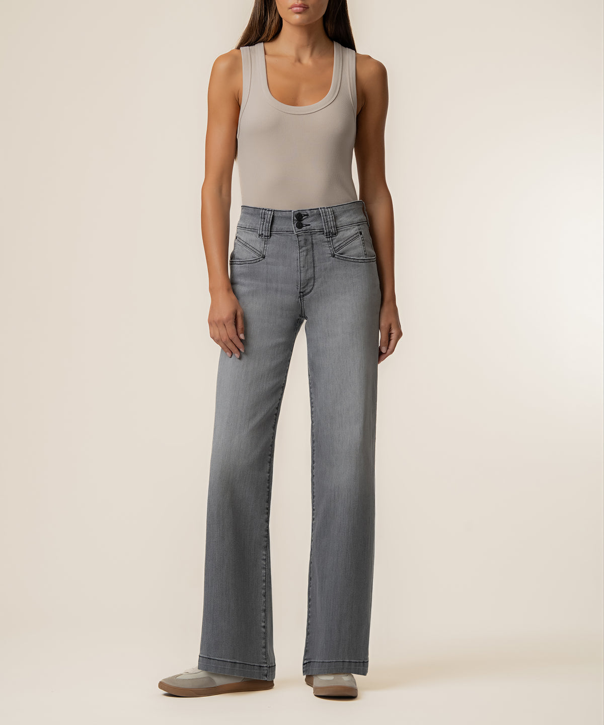 Woman wearing light gray tank top and high-rise straight-leg gray wash jeans.