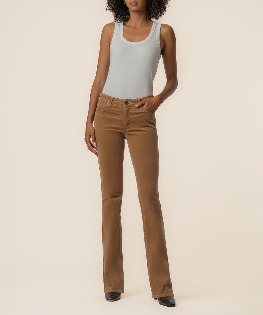 Woman wearing camel-colored corduroy bootcut pants with a light gray sleeveless tank top.