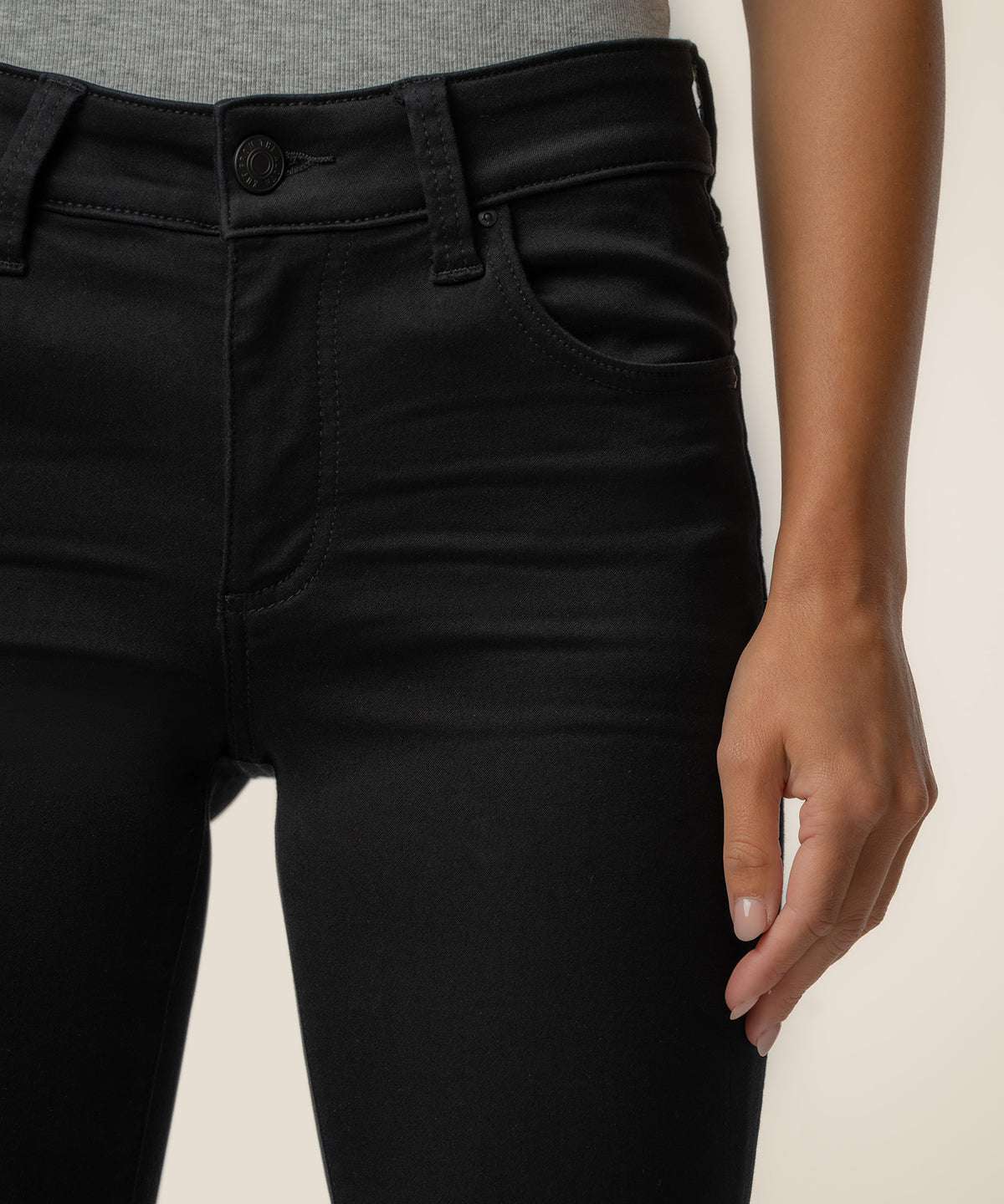Black mid-rise bootcut jeans with button closure shown on model from waist down.
