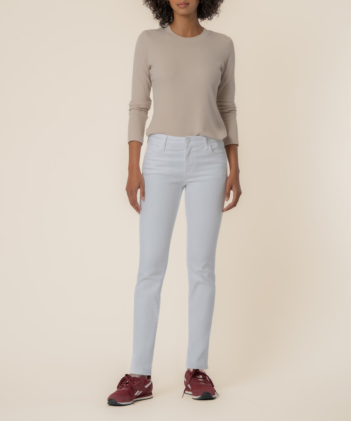 White mid-rise boyfriend jeans with a straight leg on a model wearing a beige long-sleeve top.