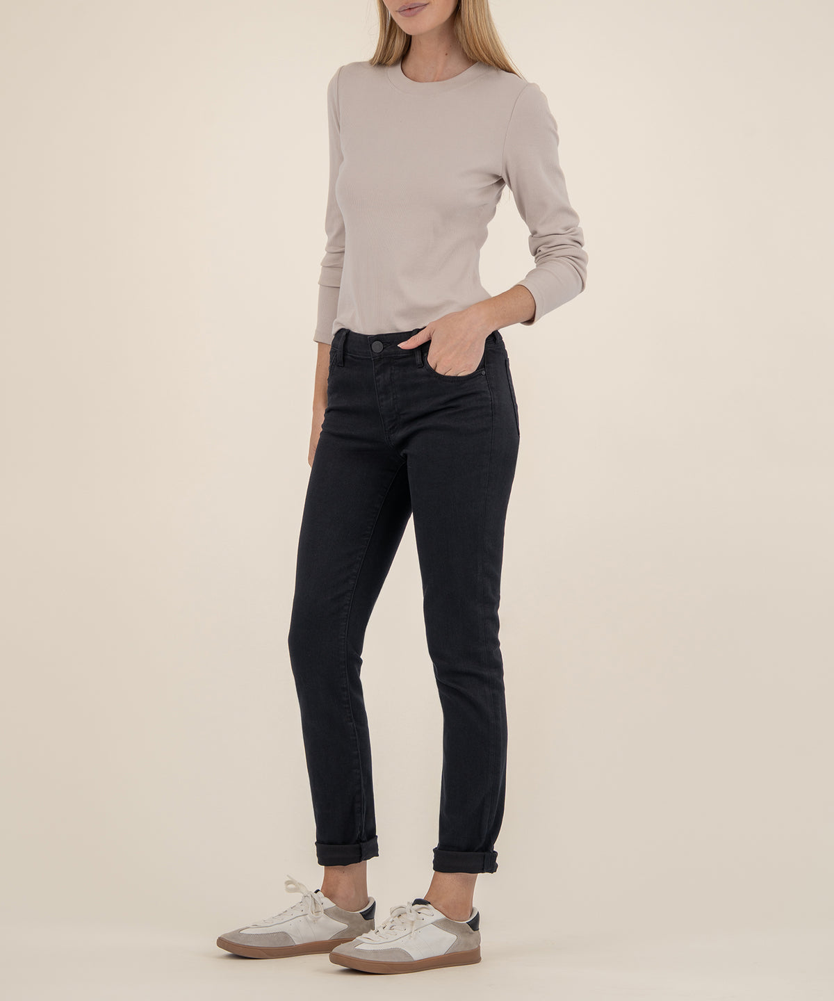 Woman wearing black mid-rise boyfriend jeans with cuffed ankles and a gray long-sleeve crew neck top.