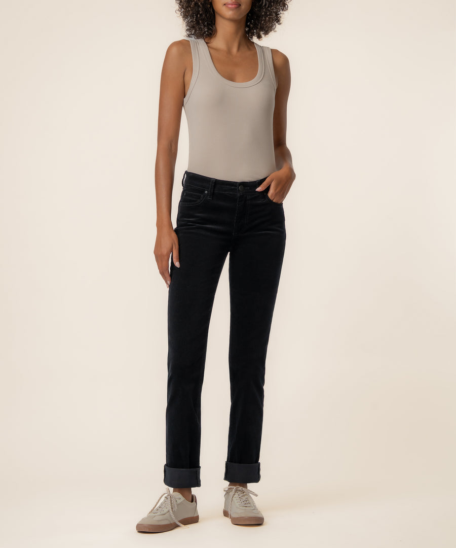 Black corduroy mid-rise boyfriend jeans with rolled cuffs, styled with a beige tank top.