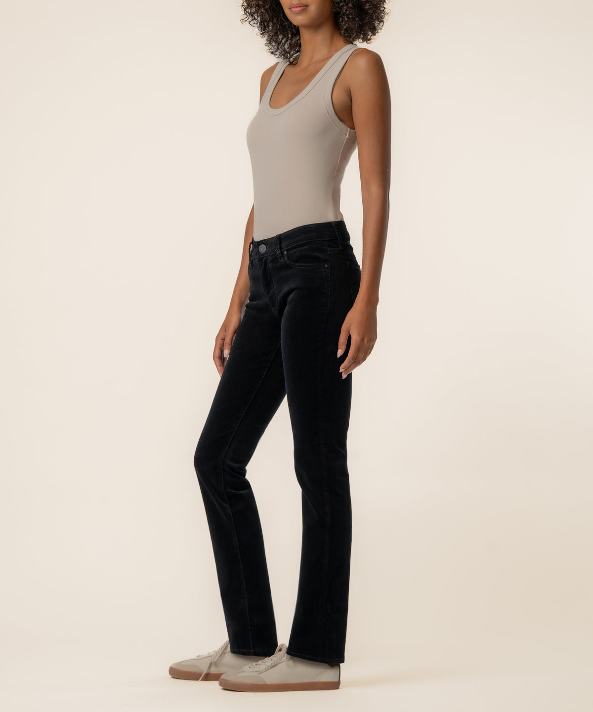 Black corduroy mid-rise boyfriend jeans with five-pocket styling, shown on model wearing beige tank top.